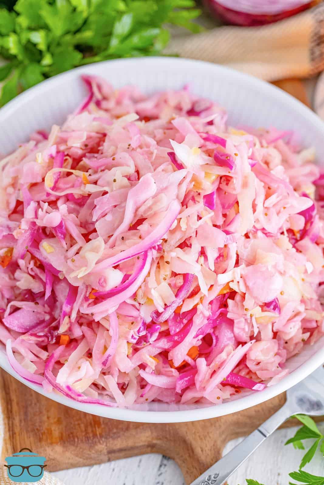 Looking down on a marinated cole slaw in a white glass bowl.