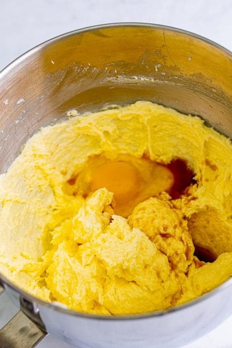 Eggs in a butter and sugar mixture in a mixing bowl.