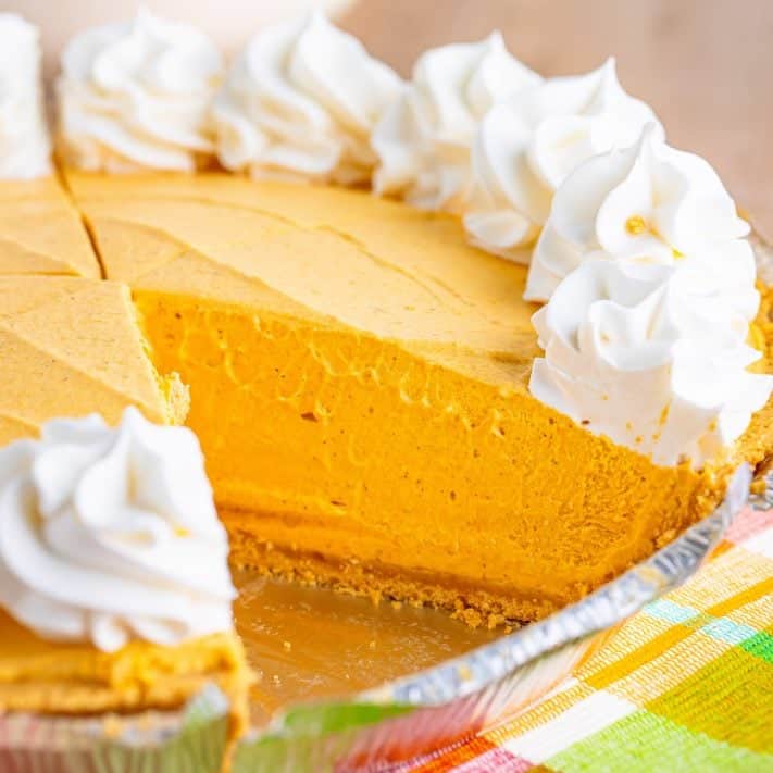 Close up looking at a Pumpkin Cheesecake with a piece removed.