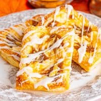A pile of pumpkin cheesecake danishes on a plate.