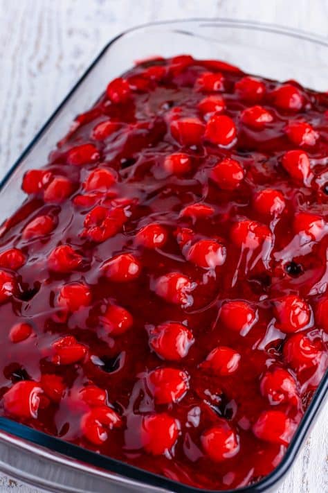 A cherry pie filling spread over a chocolate cake.