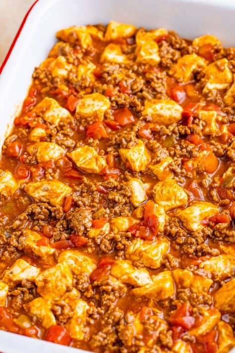 Taco meat and biscuit dough in a baking dish.