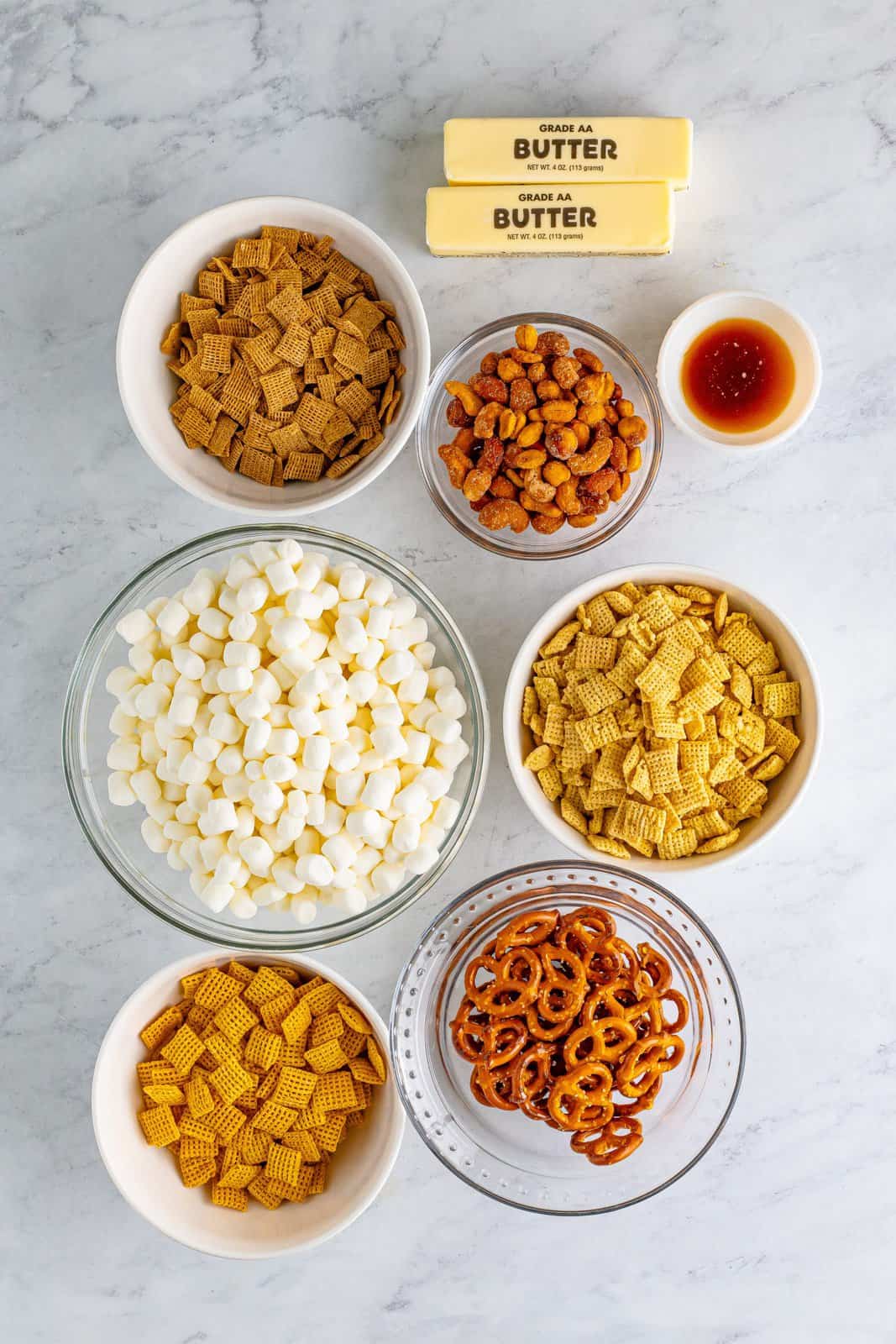 Rice chex, wheat chex, corn chex, butter, marshmallows, vanilla extract, mixed nuts, and pretzels. 
