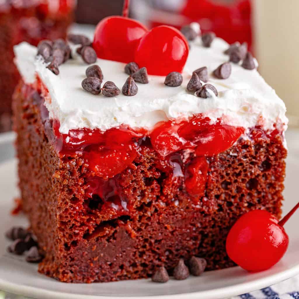 A slice of Black Forest Poke Cake on a small plate.