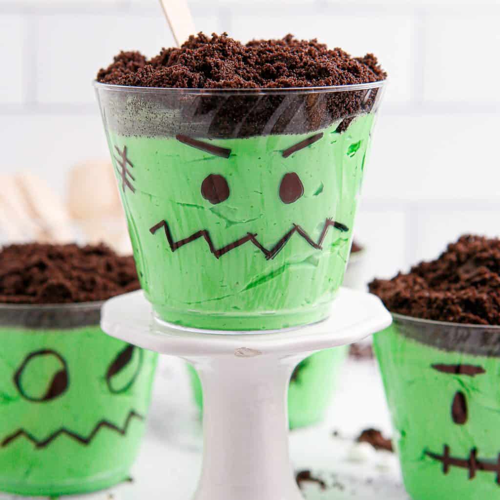 Close up looking at a Frankenstein Pudding Cup on a stand.