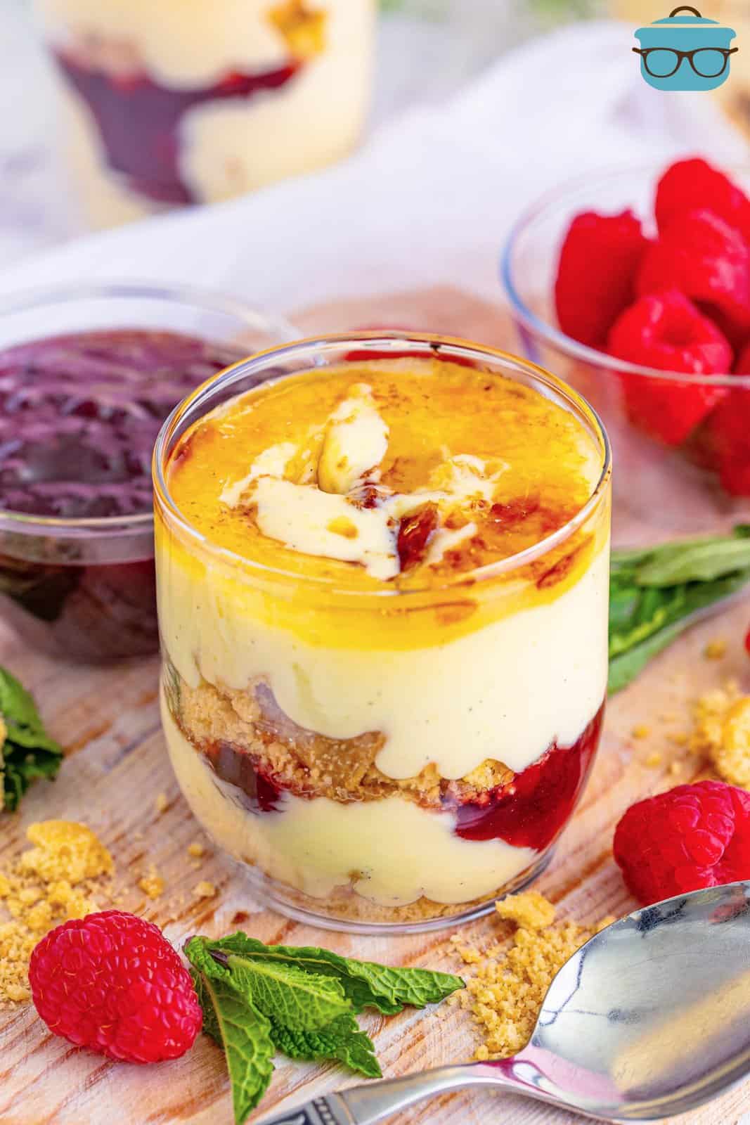 A beautiful glass of creme brulee, raspberry jam and shrotbread cookies layered to make a Creme Brulee Trifle.