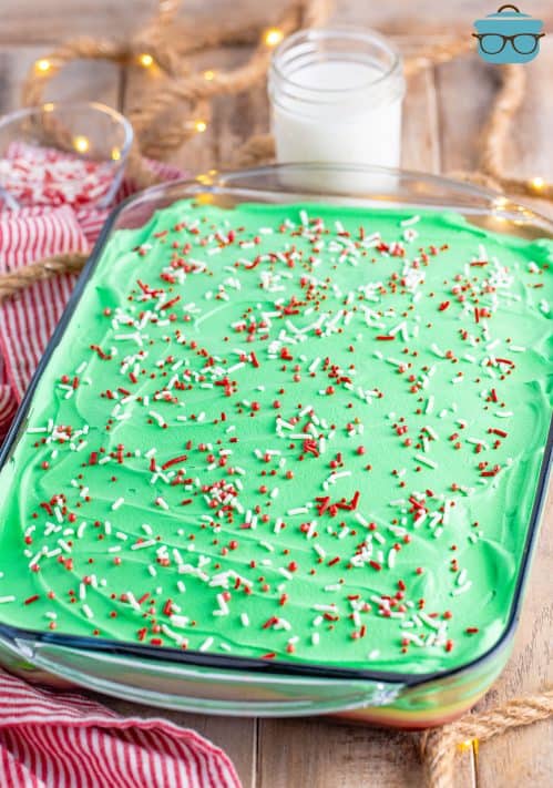 A Christmas poke cake with Christmas sprinkles.