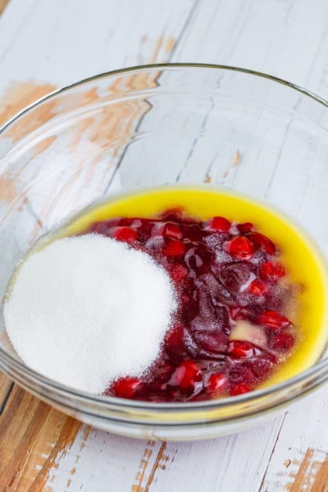 A mixing bowl with cherry pie filling, sugar, melted butter, and vanilla.