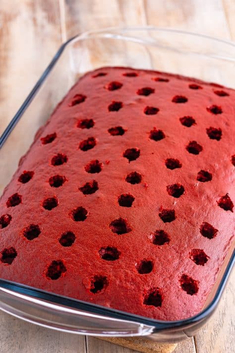 Red velvet cake with holes poked in the cake.