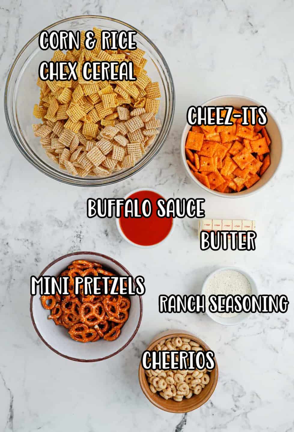 Rice chex cereal, corn chex cereal, Cheez-its, pretzel twists, Cheerios, butter, buffalo sauce and ranch seasoning.