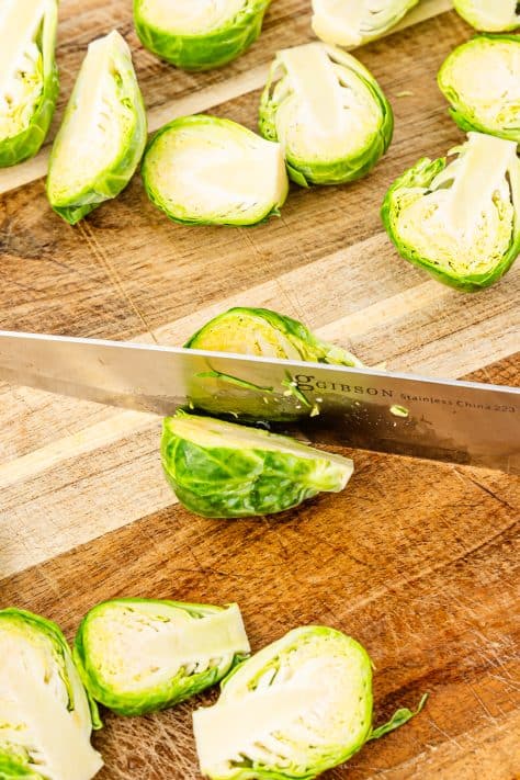 A knife cutting a brussel sprout.