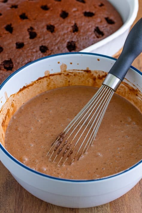 Chocolate pudding in a bowl with a whisk.