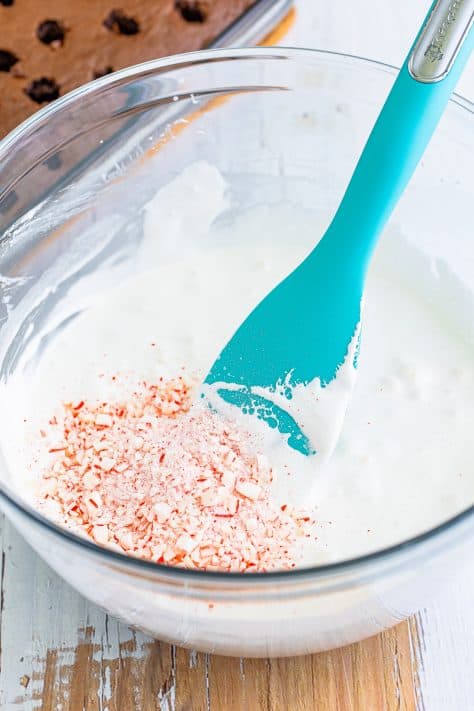 Crushed peppermint candies in a bowl of milk and marshmallow creme.