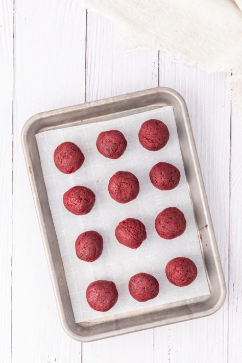 Unfrosted cake balls on a parchment lined baking sheet.