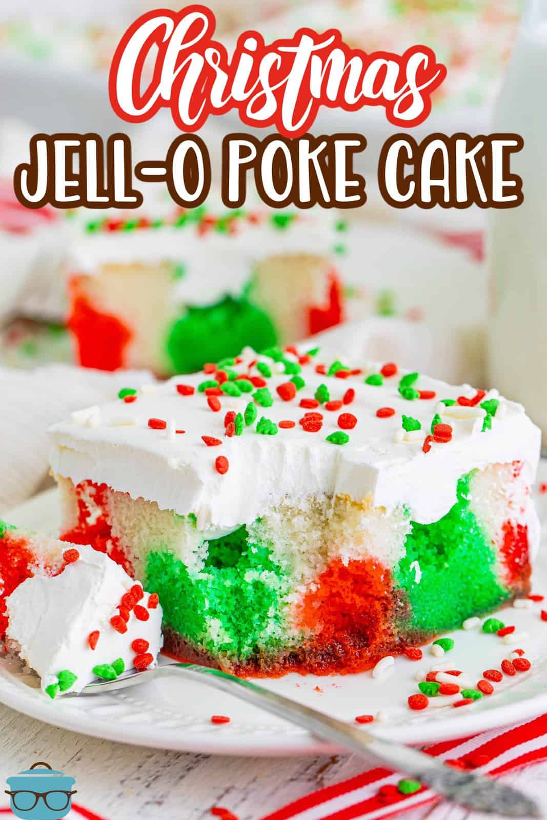 A fork with a bite of Christmas Jello Poke Cake next to the rest of the slice.