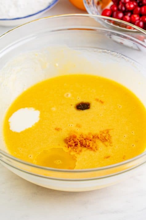 Orange zest, orange juice, milk, and vanilla extract with more wet ingredients.