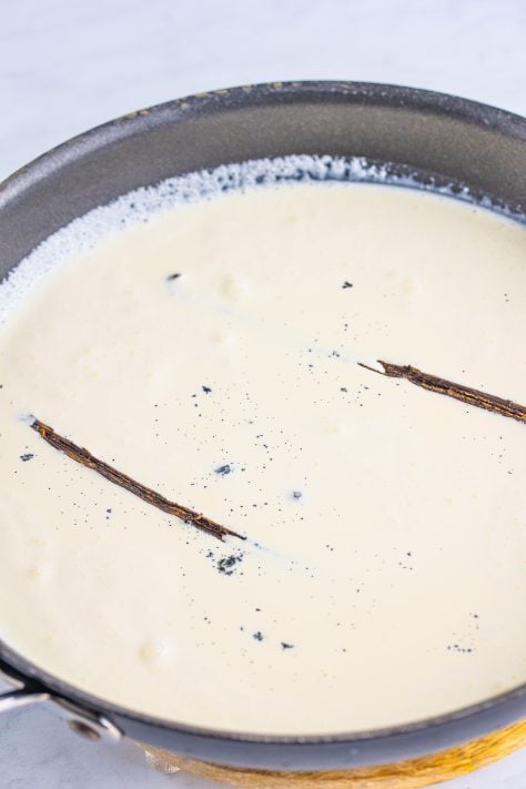 Heavy cream and vanilla bean in a pot.