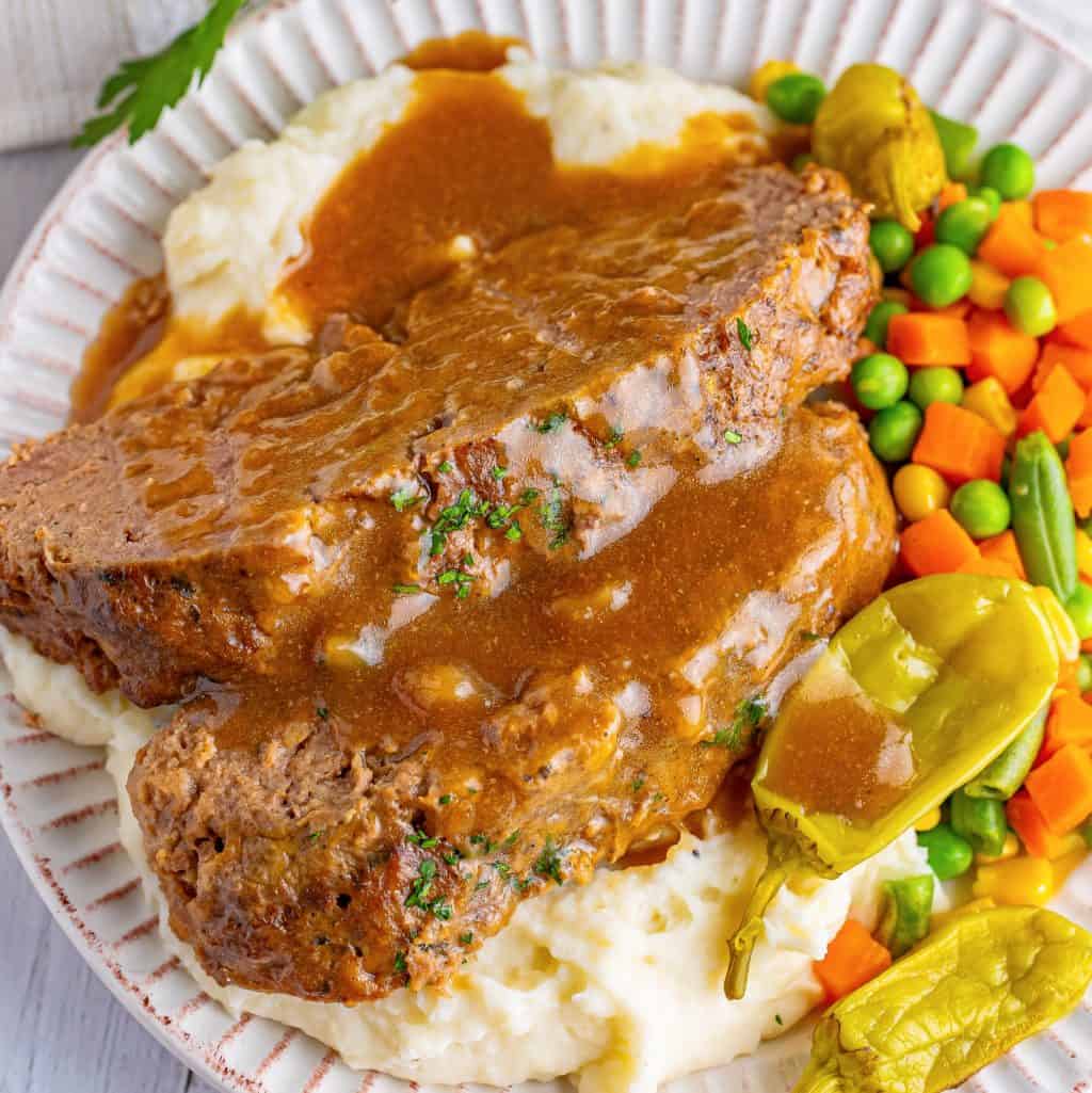 A plate of mashed potatoes, veggies and Mississippi Meatloaf.