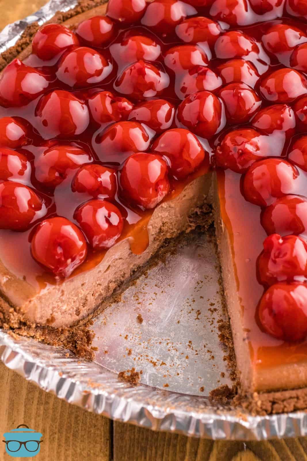 A Cherry Chocolate Cheesecake with a slice removed.