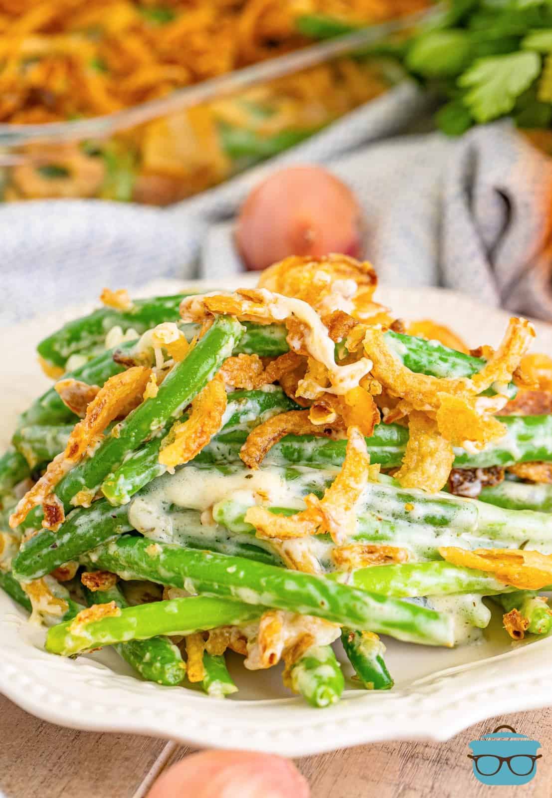 A plate with a heaping pile of Green Bean Casserole with fresh green beans.