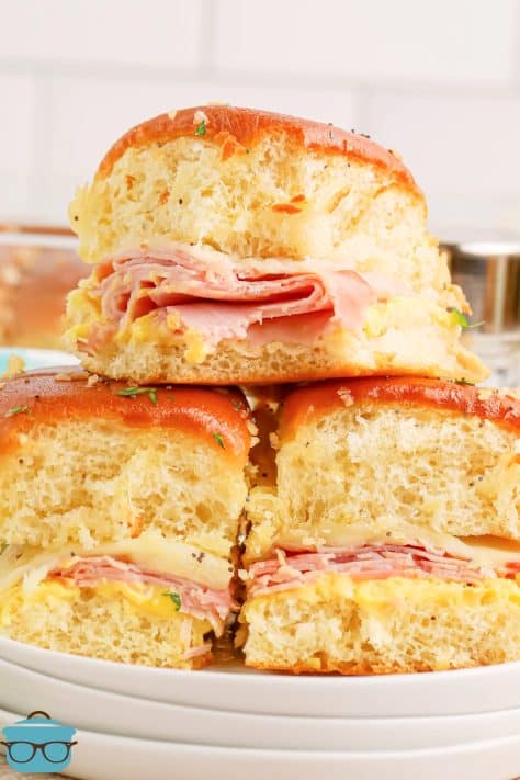 Three Honey Mustard Ham Sliders in a pile on a plate.