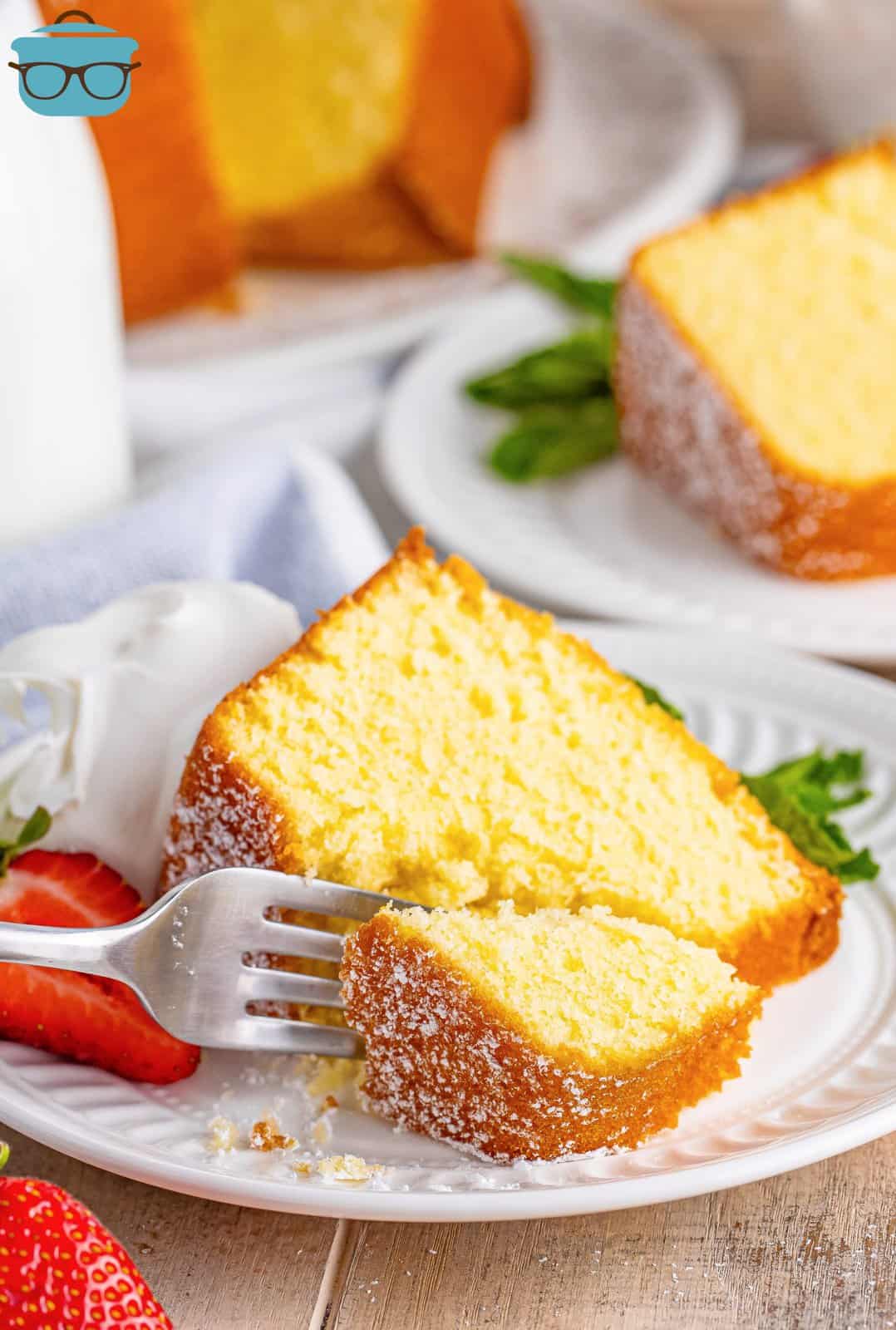 A slice of Southern Pound Cake on a plate and a fork removing a bite.