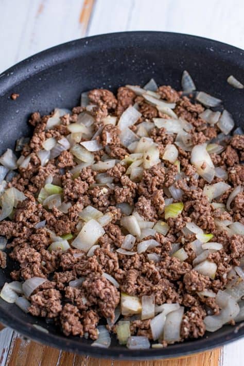 Ground beef and onion in a skillet.
