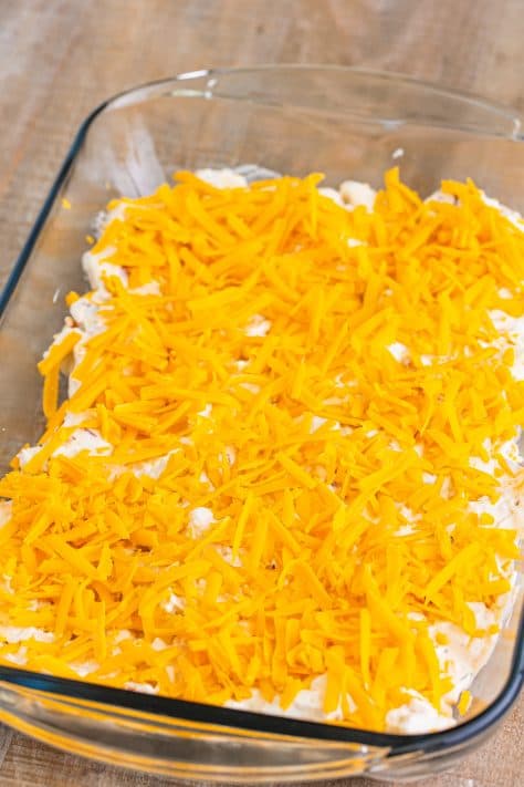 The bubble up mixture topped with cheese in a baking dish.
