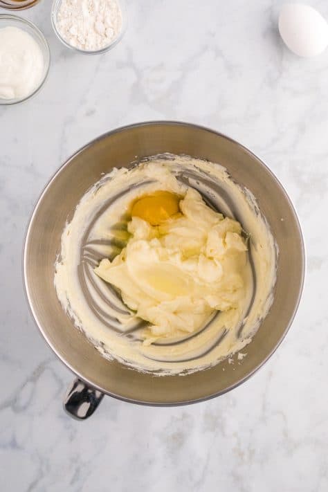 Eggs being added to cream cheese mixture in a bowl.