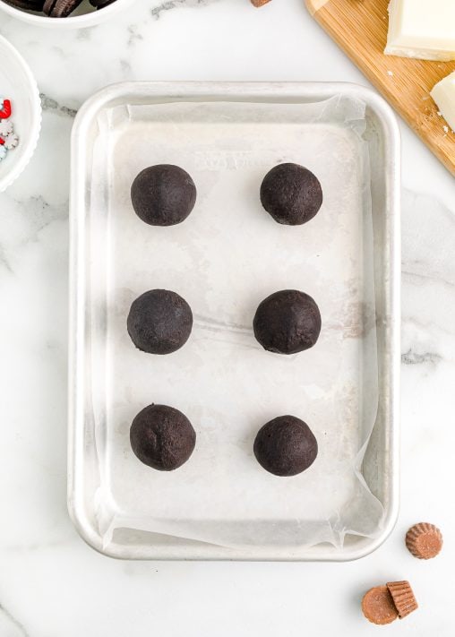 Parchment lined baking sheet with Oreo cookie balls