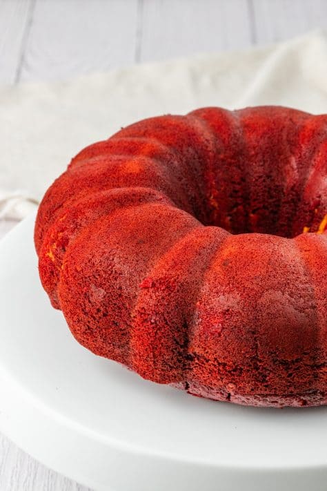 A red velvet bundt cake on a cake plate.