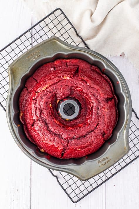A baked red velvet cake with filling in a bundt cake pan.