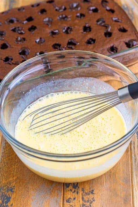 Vanilla pudding mixture in a bowl with a whisk.