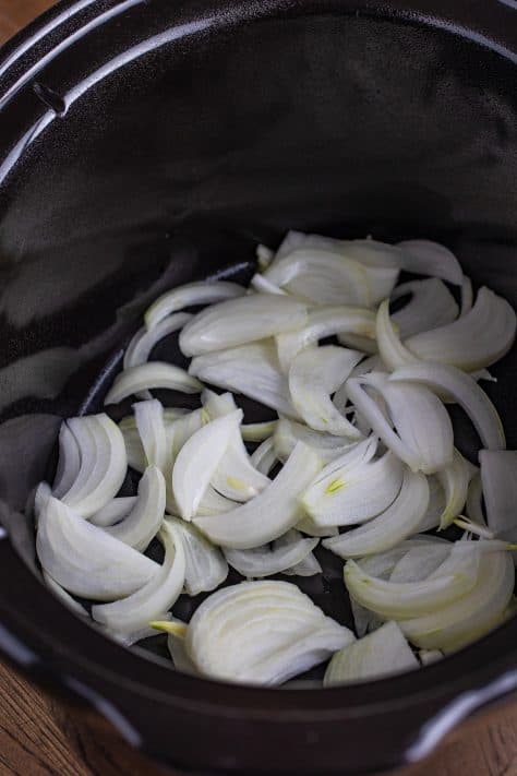 Onions in a slow cooker insert.