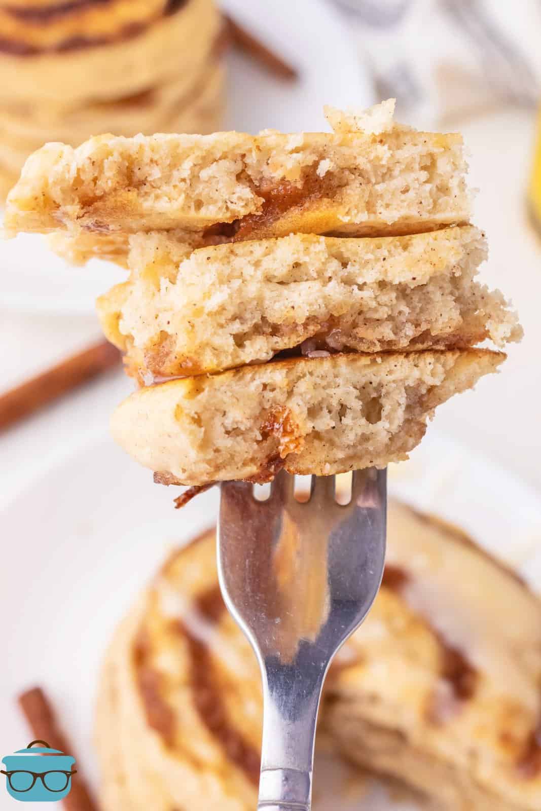 A fork holding a bite of Cinnamon Roll Pancakes.
