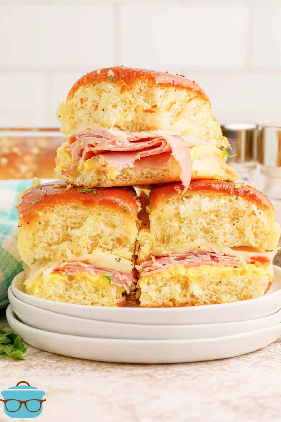 A small pyramid of Honey Mustard Ham Sliders on a serving plate.