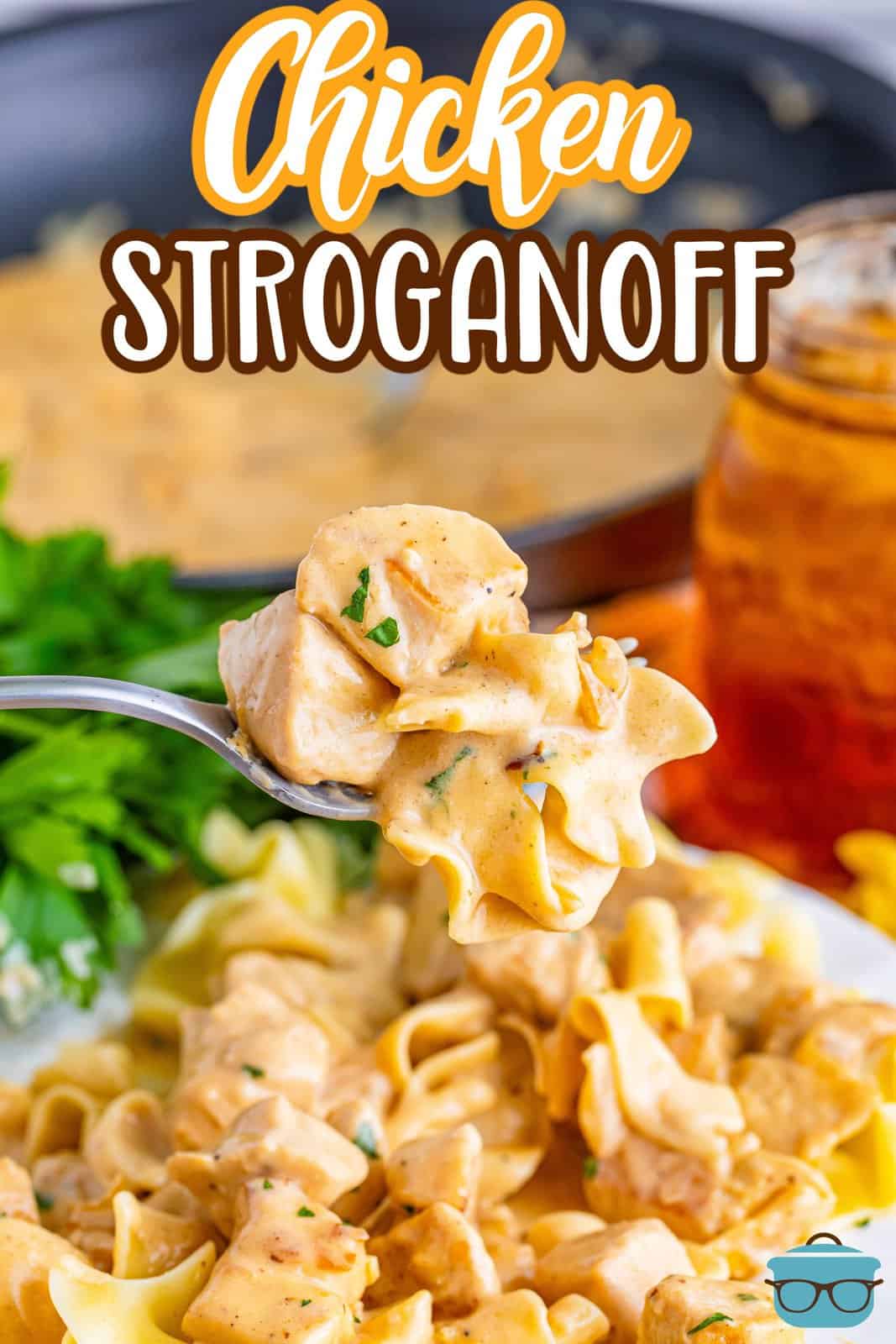 A fork holding a bite of Chicken Stroganoff above a plate of it.
