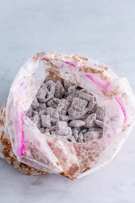 A ziplock bag with powdered sugar coated chocolate covered Chex.
