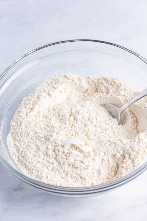 A mixing bowl with flour, baking powder, and salt.
