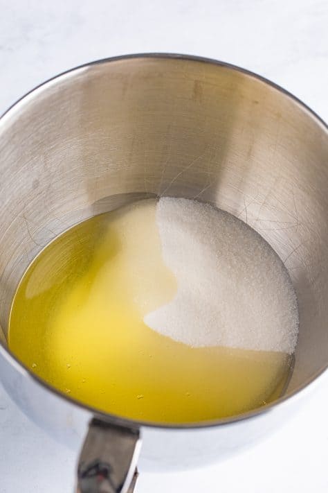 Sugar and oil in a bowl to be mixed.