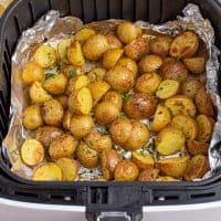 Looking down closely on an Air Fryer basket with Lemon Herb Potatoes.
