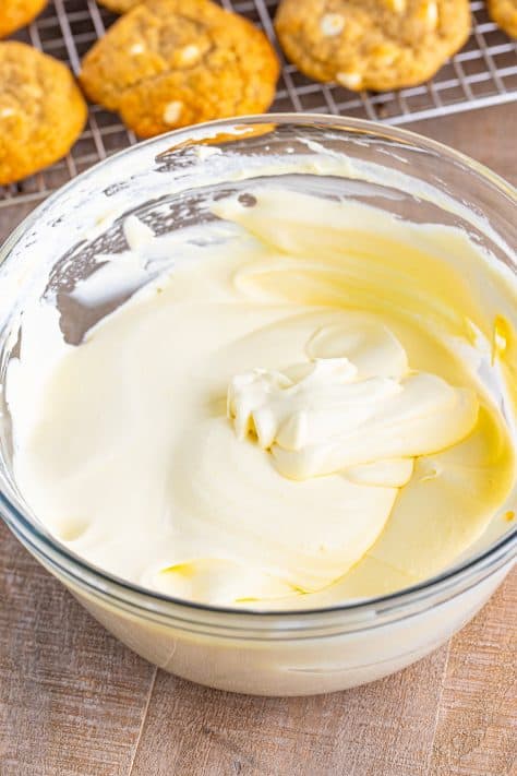 Whipped topping mixed in vanilla pudding in a mixing bowl.