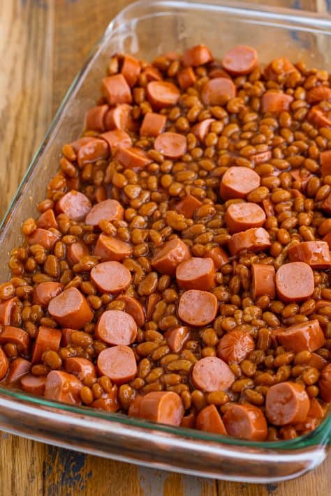 Hot dogs and beans spread out in a baking dish.