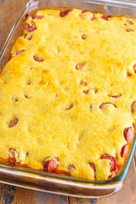 Baked beans, hot dogs, and cornbread mixture in a casserole dish.