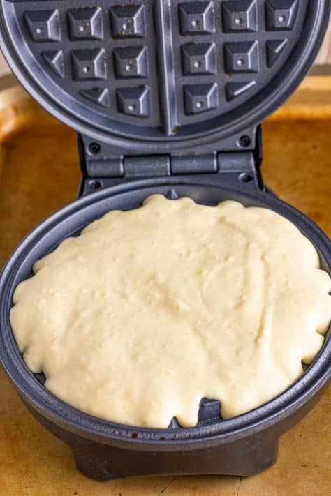Waffle batter in a waffle iron.