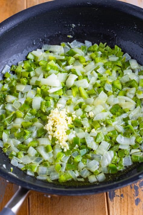 Garlic, diced onion, and bell pepper in a skillet.