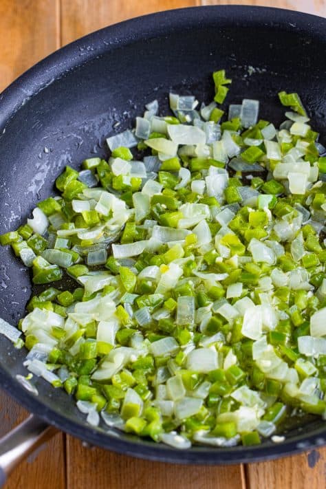 Diced onion and bell pepper in a skillet.