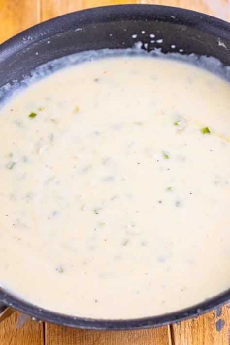 A creamy, thickened Chicken a la King sauce in a skillet.