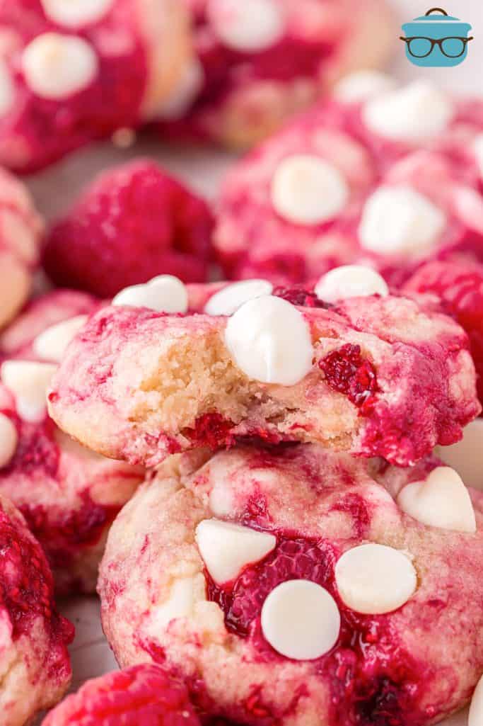 Close up looking at a few Raspberry White Chocolate Cookies, one broken in half.