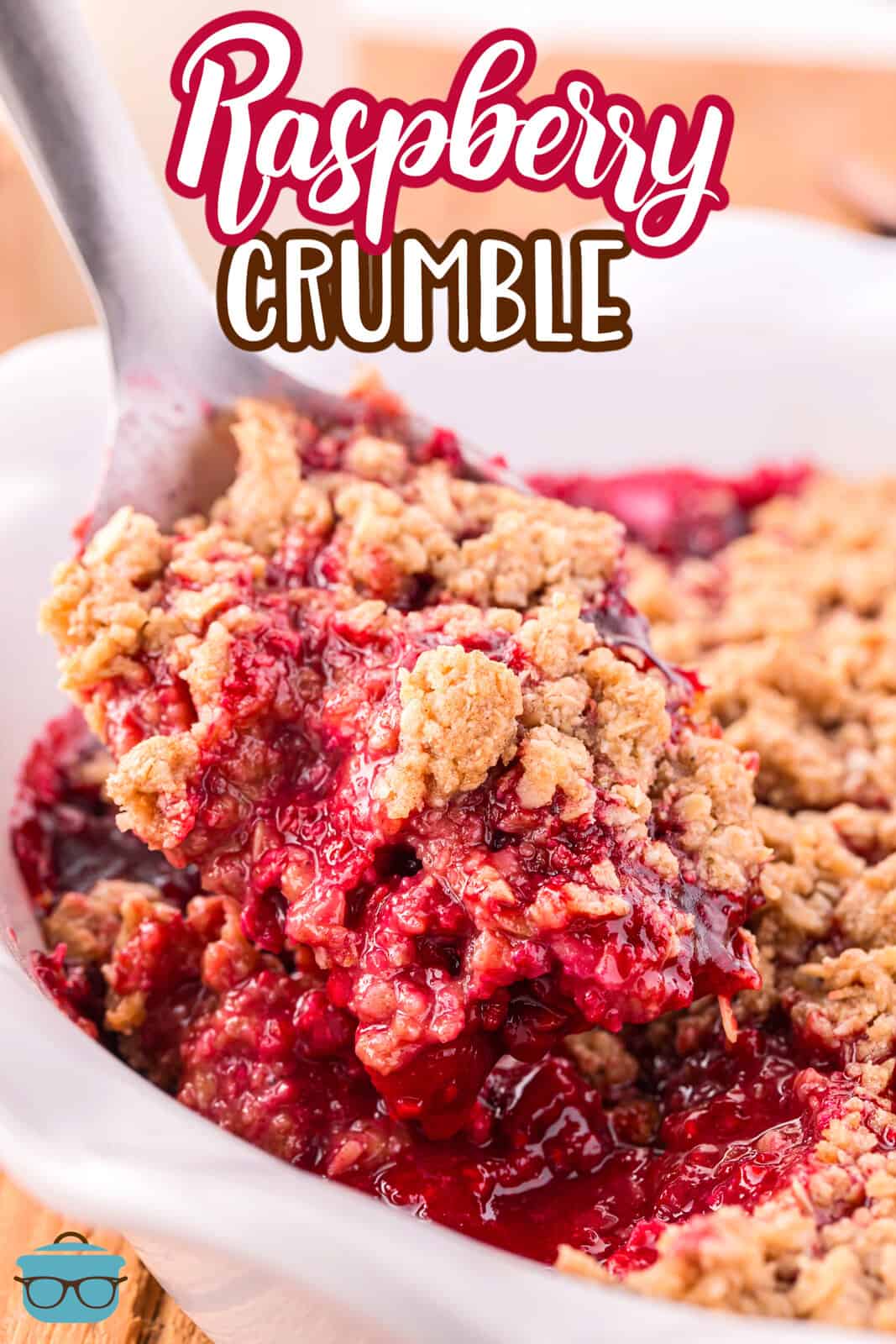 A serving utensil getting a scoop of Raspberry Crumble from a white dish.